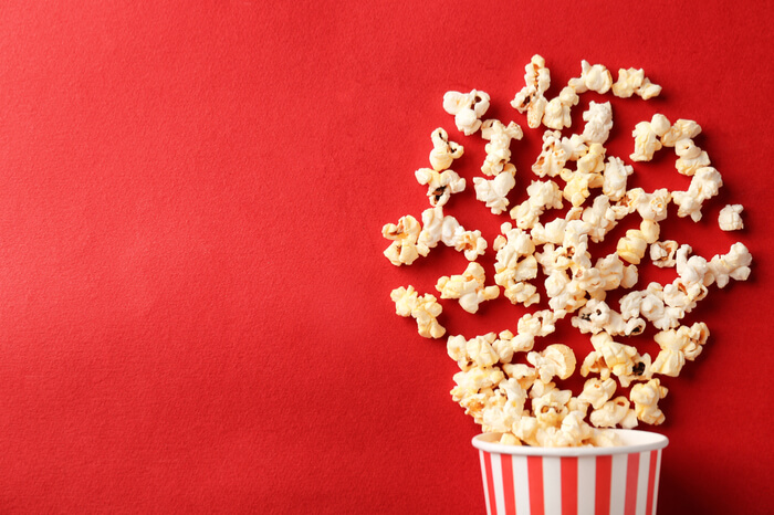 Popcorn-Becher auf rotem Hintergrund