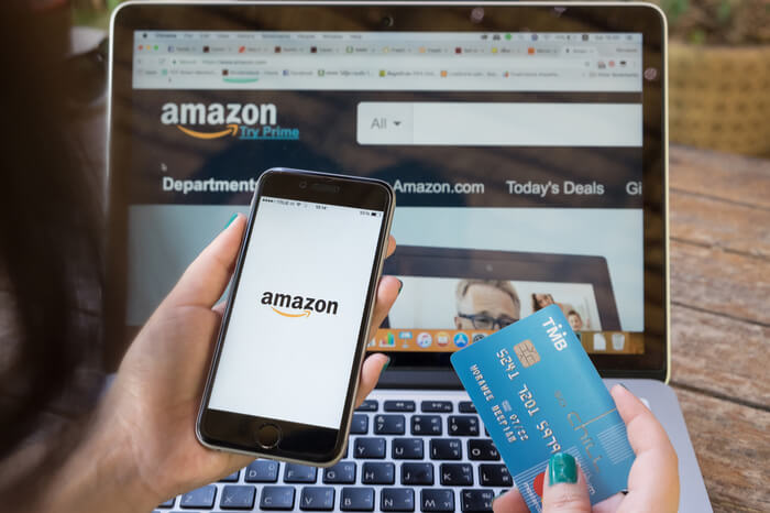 Smartphone, Kreditkarte und Laptop mit Amazon