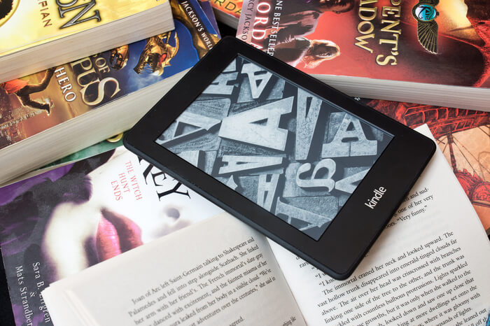 Amazon Kindle E-Book-Reader auf einem Haufen Bücher