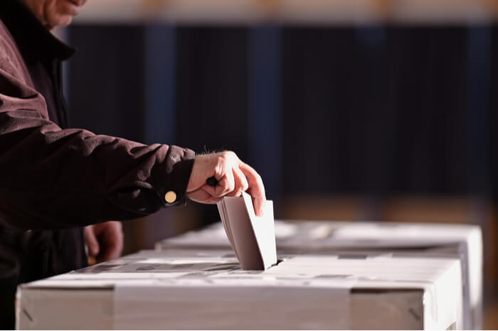 Mann wirft Wahlzettel in Urne