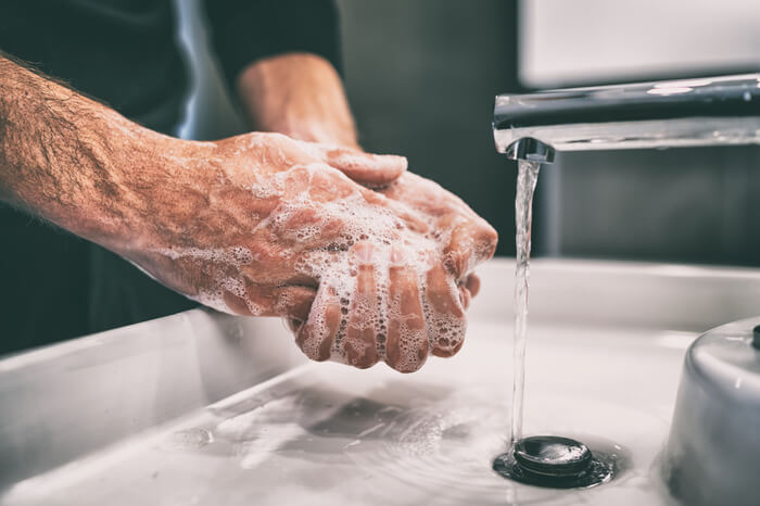 Seifenspender: Mann, der sich die Hände mit Seife wäscht