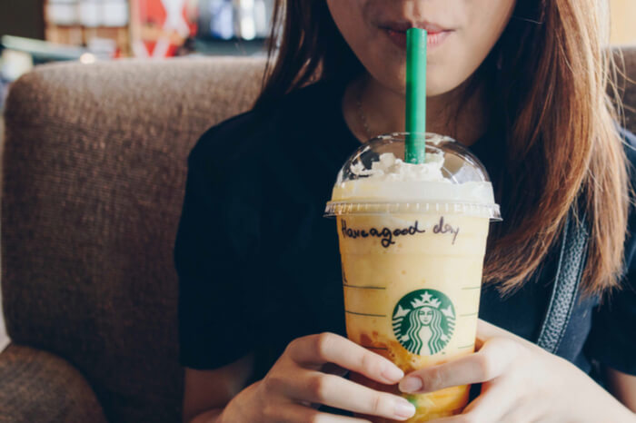 Frau trinkt Kaffee-Getränk von Starbucks