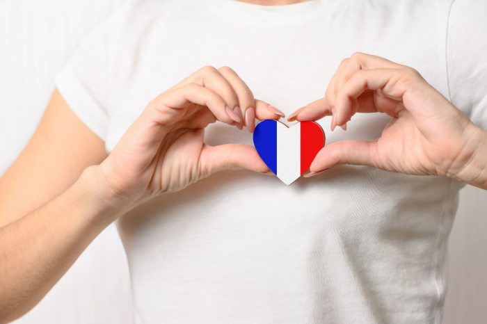 Hand hält Herz mit Frankreich Flagge