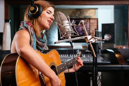 Sängerin mit Gitarre im Studio
