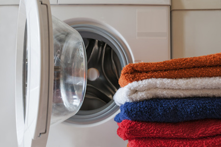 Handtücher vor einer Waschmaschine gestapelt