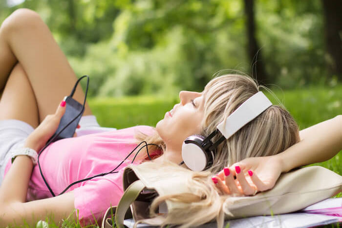 Frau streamt Musik im Park